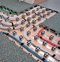 Рисунок 3. Низкопрофильный фальшпол Intercell производства Interface образует основу для построения СКС и состоит из опорной структуры высотой 60-90 мм, квадратных крышек 50х50 см и универсальных коробок для монтажа соединителей. Конструкция позволяет добавлять кабели, быстро монтируется, обладает высокой нагрузочной способностью (до 1500 кг/м2). Несущие элементы — приклеиваемые к полу стальные пьедесталы с расстоянием между центрами 125 мм. Такие полы намного дешевле фальшполов для ЦОД.