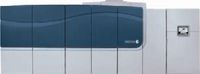 Общий вид демонстрационного устройства с рабочим названием Xerox Production Inkjet. Во время выставки проходил показ в самом простом варианте — печать с рулона на рулон. Визуально образцы были похожи на отпечатки с твёрдочернильных принтеров Phaser — тот же лёгкий маслянистый глянец на заливках, те же довольно крупные отдельные точки. Зато никакого пробивания на оборот