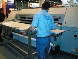 Гибридный УФ-принтер Screen Truepress Jet 2500UV (от 270 тыс. евро; себестоимость печати по чернилам — до 2,5 евро за 1 м2) оказался единственным представителем этого класса на выставке. Скорость печати до 67,5 м2/ч, разрешение до 1500dpi. Переход с рулонной на печать по плоским материалам (на снимке) занимает считанные минуты. Поставщики считают, что современные типографии недооценивают возможности, которые для них открывают УФ-принтеры