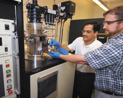 Инженеры-механики Университета им. Дж. Пэрдью Тимоти Фишер (справа) и Суреш Гаримелла демонстрируют кремниевую основу с выполненными на ней экспериментальными генераторами «ионного ветра», который будет охлаждать кристаллы микросхем. Показанное на фото оборудование плазмохимического осаждения из газовой фазы позволяет изготавливать ионные генераторы, достаточно надежные для широкого применения в коммерческих продуктах