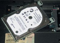 Чтобы заменить жесткий диск, необходимо вынуть его из гнезда и переставить направляющую планку, отвернув четыре винта 