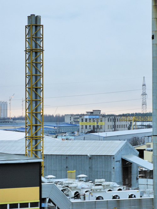 Самые интересные объекты получились на фото наименее четко. Причина в том, что доступ на них категорически запрещен. Четыре трубы — часть газопоршневой электростанции (газовый трубопровод для подачи газа от магистрали проложен под землей). Сейчас установлено четыре машины по 1,5 МВт, зарезервировано место под расширение электростанции. Рядом с ними, слева (на фото не поместились) — еще четыре такие же трубы, но они предназначены для отвода выхлопных газов от ДГУ (тоже четыре агрегата по 1,5 МВт).