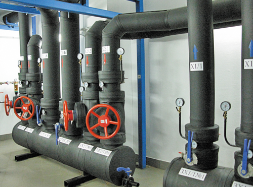 Через коллекторную холодная вода от чиллеров направляется к машинным залам, а обратно идет отработанная горячая вода. Для того чтобы зимой вода не замерзала, проложенные между чиллерами и зданием ЦОД трубы помещены в специальную изоляцию с греющим кабелем. Все контуры системы охлаждения продублированы. По трубам, помеченным синими стрелками, поступает холодная вода, красные стрелки означают отвод горячей. Выполнено секционирование: при протечке задвижки позволяют отсечь соответствующий участок трубы.